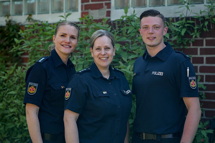 Auf dem Foto sind drei uniformierte Polizisten zu sehen, die zukünftig die queersensible Anzeigenaufnahme anbiten.
