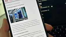 Hand,  die ein Handy hält auf der die Homepageseite des Präventionszentrums der Polizei Bremen abgebildet ist.