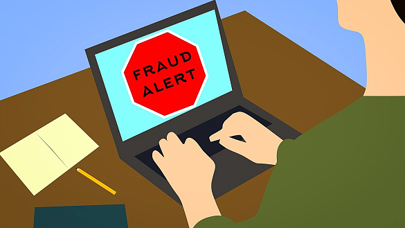 Geöffneter Laptop mit auf dem Bildschirm eingeblendeten Text Fraud Alert