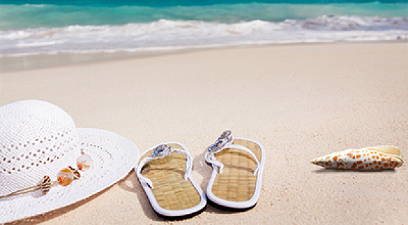 Badelatschen, Sonnenhut im Sand am Meer