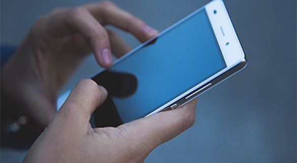 Hand, die ein Mobiltelefon hält 