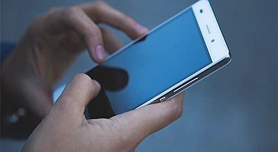 Hand, die ein Mobiltelefon hält 
