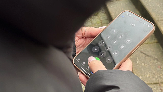 Person hält Handy in der Hand und hat die 110 in das Displayfeld getippt