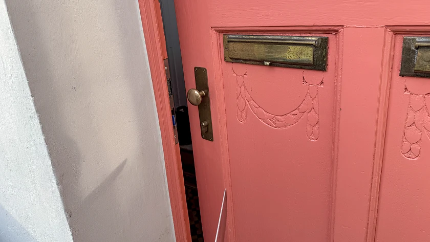 An der Wand einer geöffneten Tür erkennt man den Schatten eines Messers 