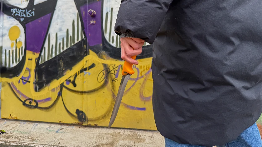 Dunkel gekleidete Person hält ein Messer in der Hand