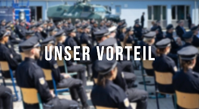 Auf dem Foto sind mehrere Personen in Polizeiuniform, die in mehreren Reihen auf Stühlen sitzen