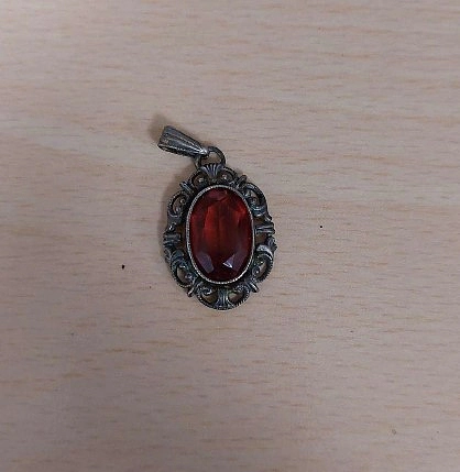 Anh&auml;nger in silber mit rotem Stein.