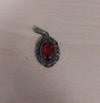 Anhänger in silber mit rotem Stein.