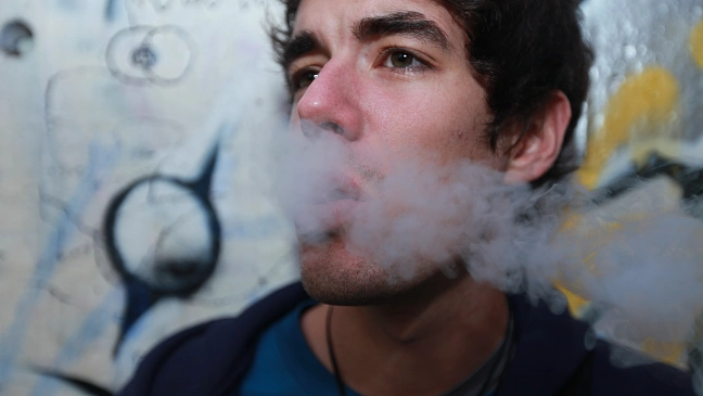 Mann, der Qualm aus seinem Mund bläst