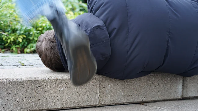 Fußtritt in Richtung des Kopfes eines am Boden liegenden Mannes 