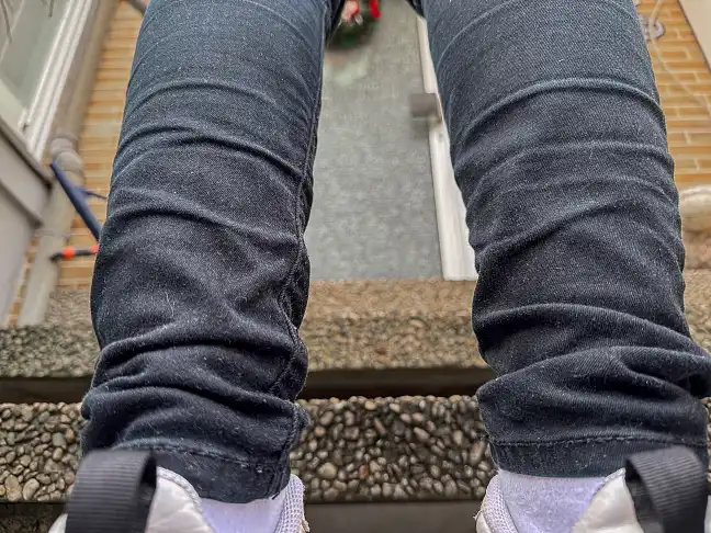 Dunkel gekleidete Person steht an einer Haustür